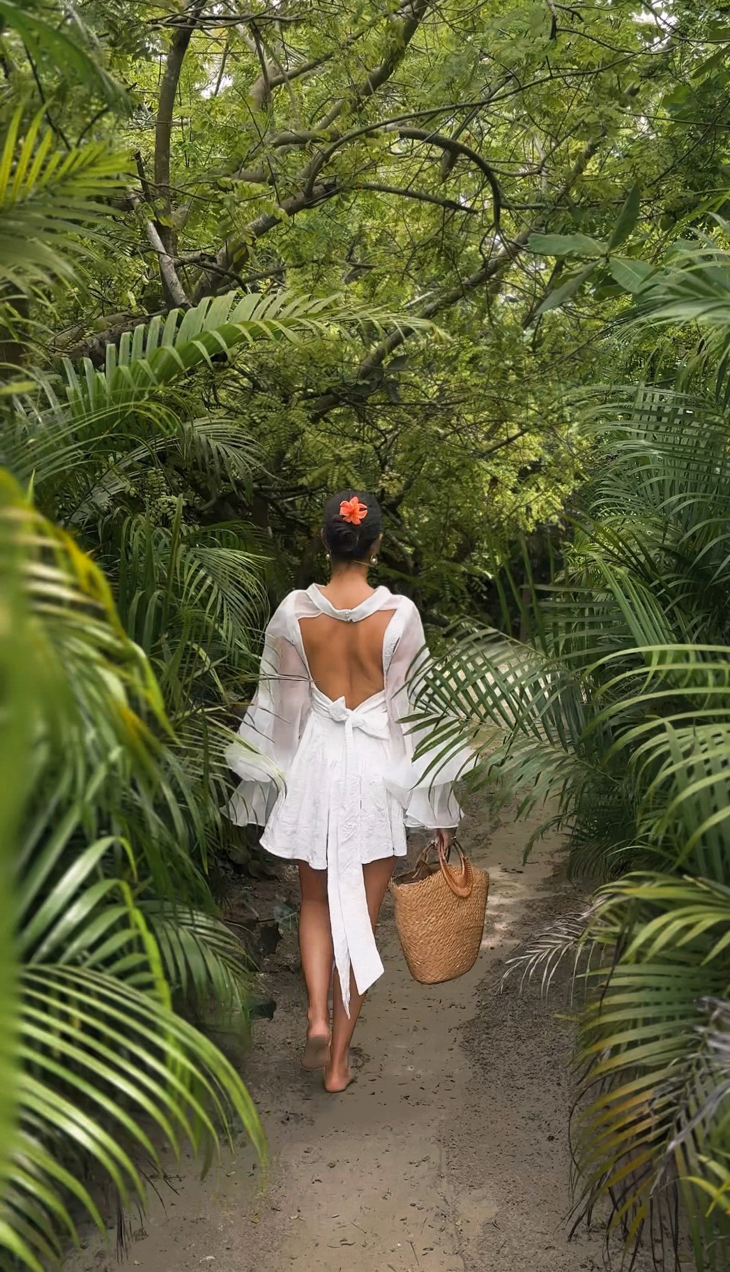 Guest walking through a lush tropical pathway