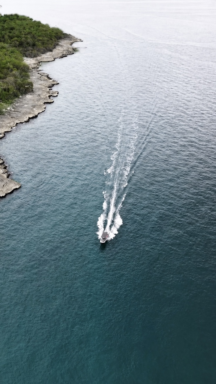 Boat crossing clear blue coastal water